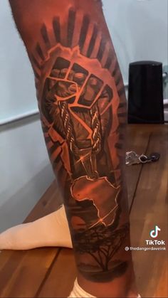 a man's leg with a tattoo on it that has an image of jesus holding the cross