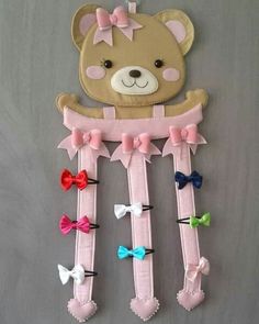 a teddy bear is hanging on the wall next to some hair clips and a bow tie