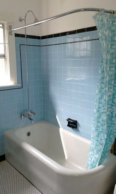 a bath tub sitting next to a window in a bathroom