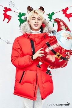 a person in a red coat holding a santa clause balloon with reindeer decorations on it