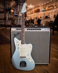 an electric guitar sitting on top of a hard wood floor next to a speaker and amp