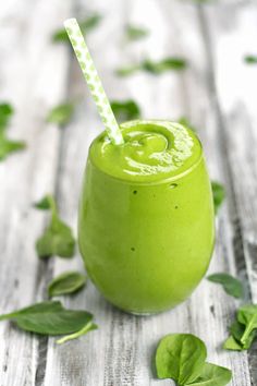 a green smoothie with a straw in it