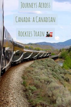 a train traveling down tracks next to a lush green hillside