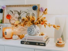 a table with books, vases and candles on it