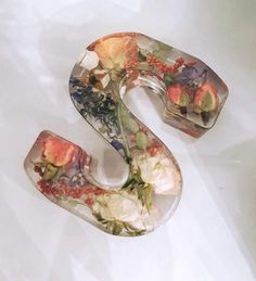 the letter s is made out of glass and flowers on it's sides,