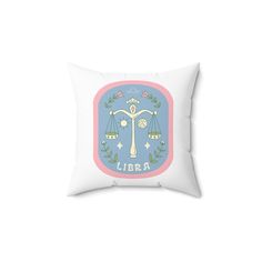 a white pillow with a blue and pink design on the front, featuring an image of scales