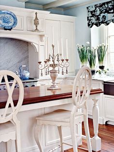 a kitchen with white cabinets and an island in front of a stove top oven next to a sink