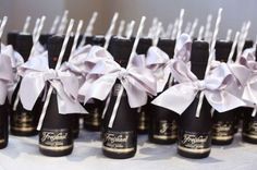 an image of some bottles that are on the table with white ribbons and bowknots