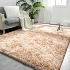 a living room area with a couch, chair and rug on the floor in front of a window