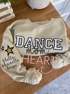 ** Please read before buying **  Personalized Embroidered Dance Mom Shirt with glitter HTV applique. Fit: Unisex, Fits loose/relaxed Sizing: S,M,L,XL,2XL Material: 50% Cotton, 50% Polyester Embroidery Details: "Dance Mom" centered across the chest Stars and Child name on right shoulder sleeve ** Please note the picture is a sample only & it will be made once the order is placed. Colors will vary slightly due to lighting & device settings ** If you don't see the colors you are looking for, please Dance Moms Outfits, Dance Mom Shirt, Embroidered Products, Dance Mom Shirts, July Fashion, Dance Shirt, Bow Shirt, Dance Mom, Bow Shirts