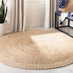 a large round rug in the corner of a room with a chair and potted plant