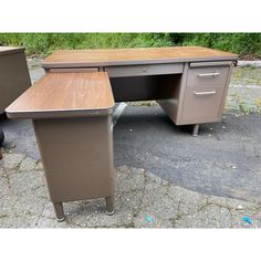 two metal desks sitting next to each other on top of a street side walk