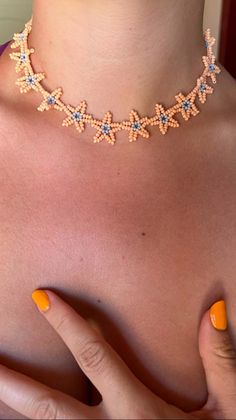 a close up of a woman's chest wearing an orange and blue beaded necklace