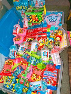 a plastic container filled with lots of different types of toys and snacks on top of a table