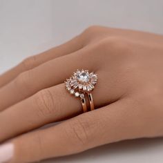 a woman's hand with a diamond ring on top of her finger and an engagement band