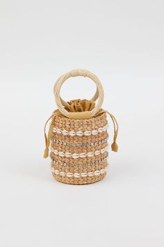 Our Leah Bag is our new favorite mini bag for spring and summer! With shell and stone embellished detail on a simple straw bag with round handles, this handheld adds style and personality to any outfit.  Material: 100% straw, 100% Cotton Lining, Shell and Stone Detail Spot Clean with Damp Cloth Elegant Vacation Bucket Bag With Bamboo Handle, Beige Bucket Bag With Detachable Handle For Beach, Beach Tote Straw Bag With Detachable Handle, Bohemian Top Handle Bucket Bag For Summer, Beach Straw Tote Bag With Detachable Handle, Beige Shoulder Bag With Pearl Handle For Vacation, Handheld Straw Bag With Detachable Handle For Beach, Summer Bags With Pearl Handle In Natural Color, Summer Pouch Bucket Bag With Detachable Handle