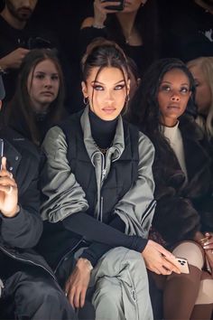 two women sitting next to each other at a fashion show