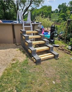 an outdoor hot tub with steps made out of cinder blocks and wooden boards in the foreground