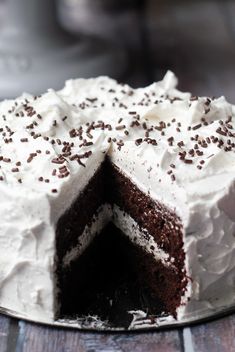 a cake with white frosting and chocolate sprinkles