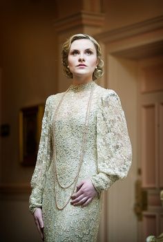 a woman in a white dress and pearls