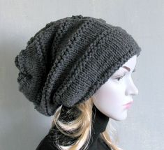 a mannequin head wearing a gray knitted hat