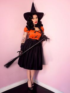 a woman dressed as a witch holding a broom