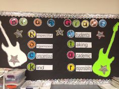 a bulletin board decorated with different types of musical instruments and words on black paper, surrounded by other school supplies