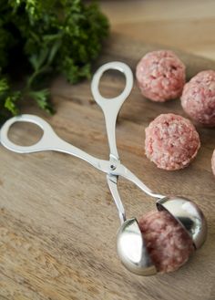 some meatballs are on a cutting board with a pair of scissors