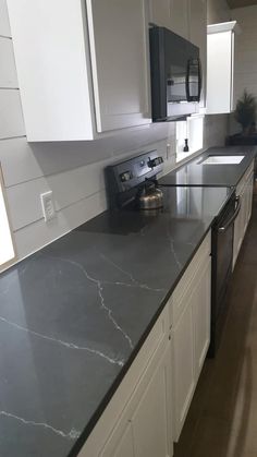 a kitchen with marble counter tops and white cabinets