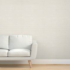 a white couch sitting in front of a wall