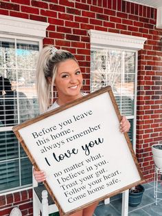 a woman holding up a sign that says, before you leave this home, always remember i love you