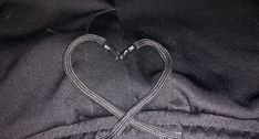 a heart - shaped knot is on top of a black satin fabric material, which has been stitched together