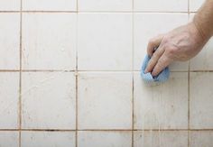 a hand with a sponge on a tiled floor