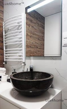 a black bowl sink sitting on top of a white counter