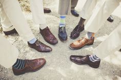 a group of people standing next to each other wearing dress shoes with socks on them