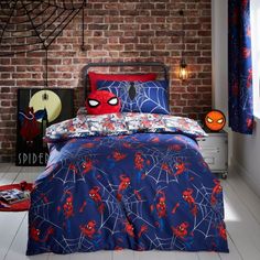 a spiderman themed bedroom with red and blue bedding, pillowcases and curtains