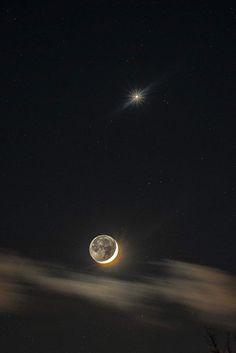 the moon is shining brightly in the night sky with clouds and stars above it,