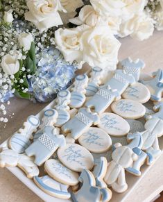 decorated cookies are on a tray next to white flowers and blue hydranges with baby's breath written on them