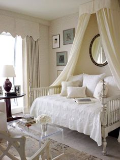 a bedroom with a canopy bed and white furniture