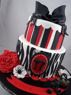 a three tiered cake decorated with black, white and red designs