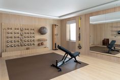 a home gym with exercise equipment, mirrors and other items on the wall in front of it