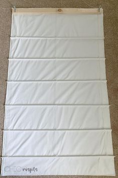 a white wall hanging on top of a carpeted floor