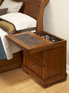 a bed with a wooden headboard and night stand next to it on top of a hard wood floor