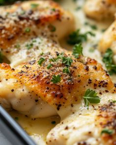 some chicken with parsley on top of it in a pan