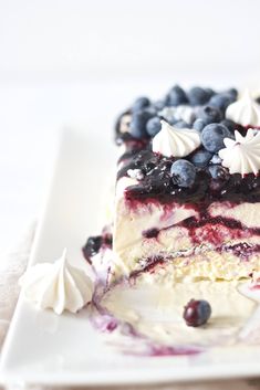 a piece of cake with blueberries and whipped cream