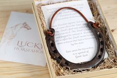 a horse shoe necklace in a box on a table