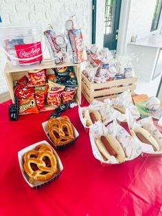 hot dogs, pretzels and other snacks on a table