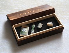 a wooden box with four cufflinks in it