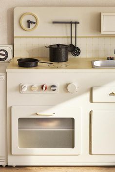 a white stove top oven sitting inside of a kitchen next to a wall mounted clock