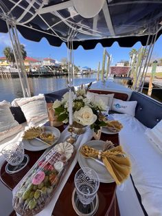 the table is set up on the boat for guests to enjoy their meal and drink